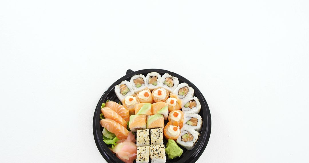 Assortment of Sushi Rolls on Black Plate with White Background - Free Images, Stock Photos and Pictures on Pikwizard.com