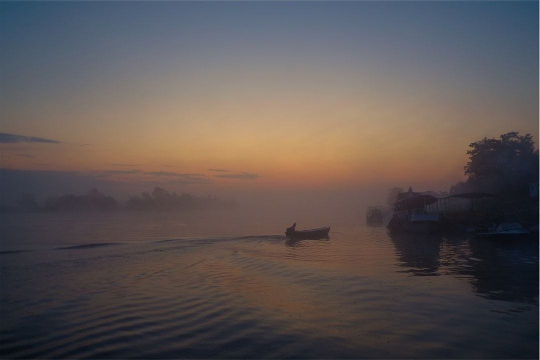 Serene Sunrise Over Misty River with Boatman - Free Images, Stock Photos and Pictures on Pikwizard.com