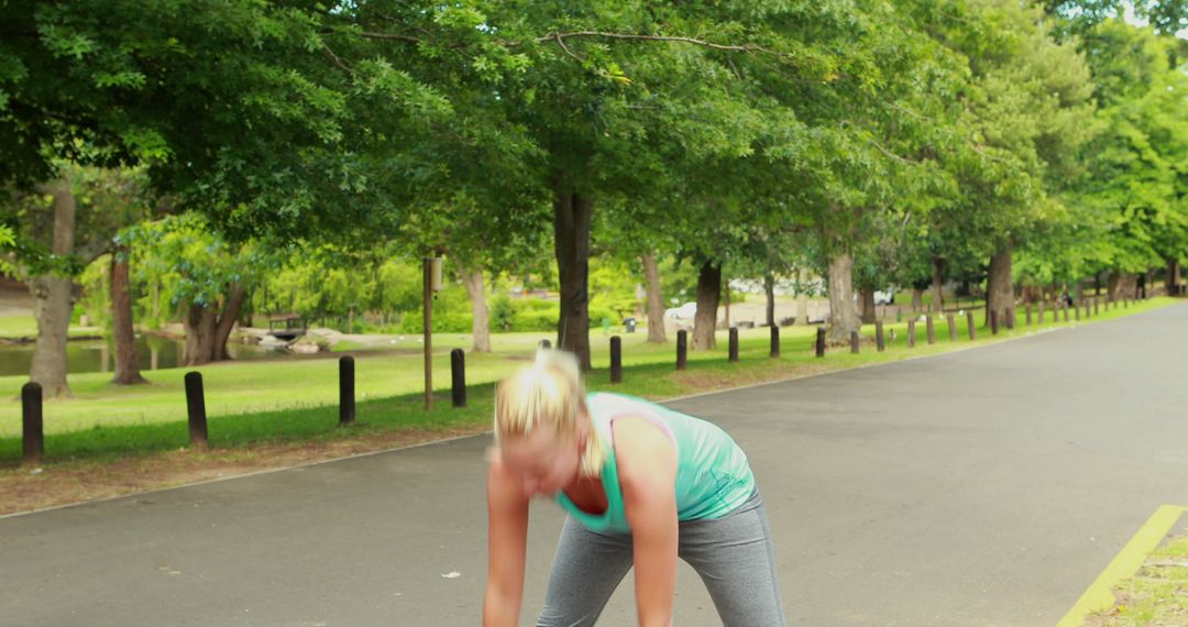 Woman stretching in sunny park preparing for exercise routine - Free Images, Stock Photos and Pictures on Pikwizard.com