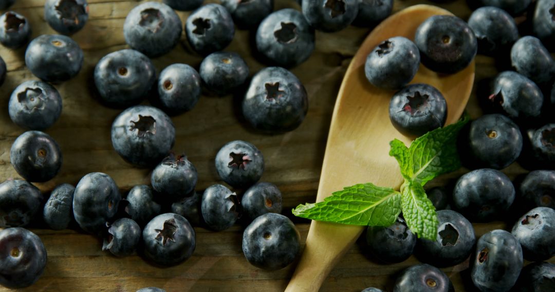 Fresh Blueberries with Wood Spoon and Mint Leaves on Rustic Table - Free Images, Stock Photos and Pictures on Pikwizard.com