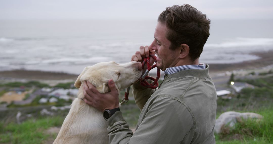 Man Bonding with Dog while Overlooking Coastal Landscape - Free Images, Stock Photos and Pictures on Pikwizard.com