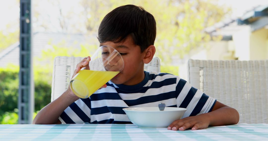 Child Drinking Juice During Breakfast Outdoors - Free Images, Stock Photos and Pictures on Pikwizard.com