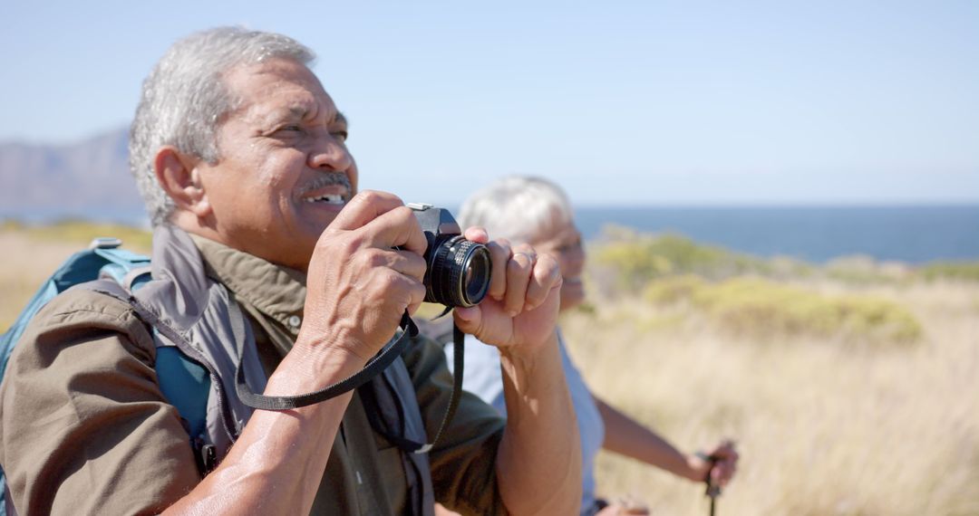 Senior Man Photographing Outdoors During Nature Hike - Free Images, Stock Photos and Pictures on Pikwizard.com