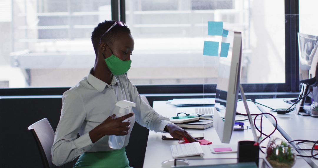 Office Worker Wearing Mask Disinfecting Workspace - Free Images, Stock Photos and Pictures on Pikwizard.com