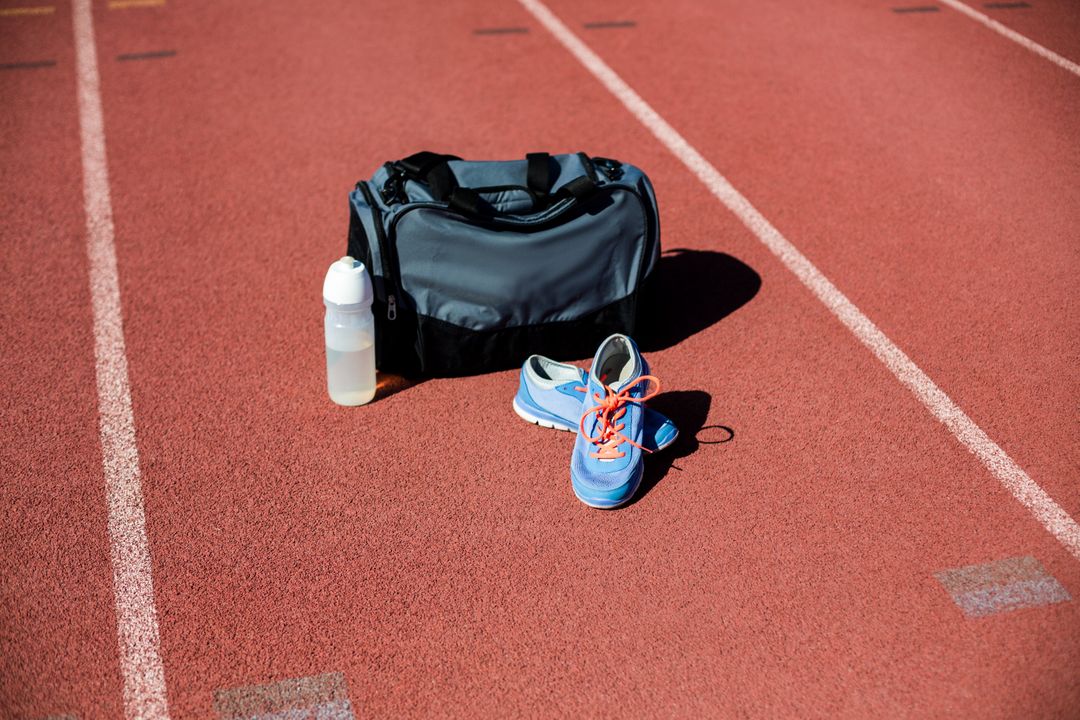 Sports Bag, Shoes, and Water Bottle on Running Track - Free Images, Stock Photos and Pictures on Pikwizard.com