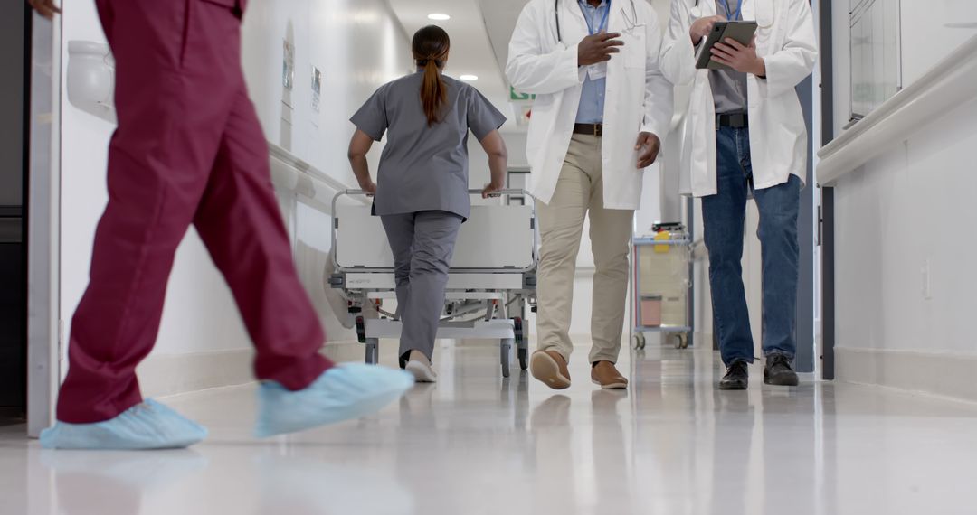 Medical Team Walking Down Hospital Corridor with Emergency Bed - Free Images, Stock Photos and Pictures on Pikwizard.com