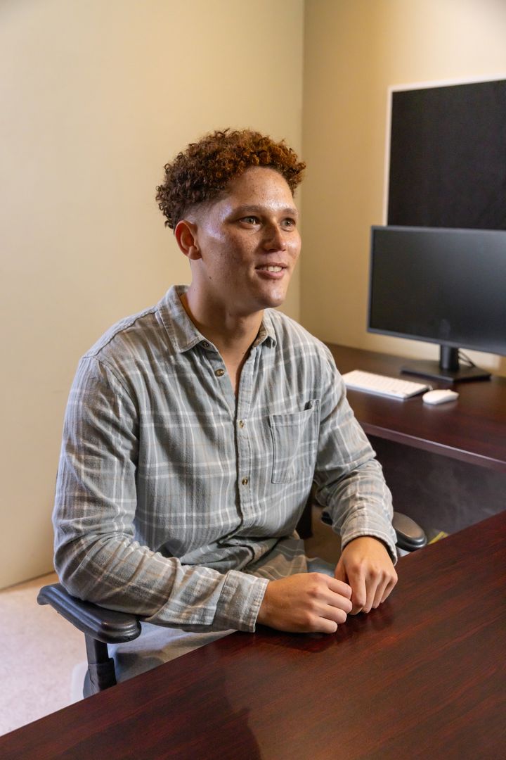 Professional Man Engaged in Office Discussion with Technology Setup