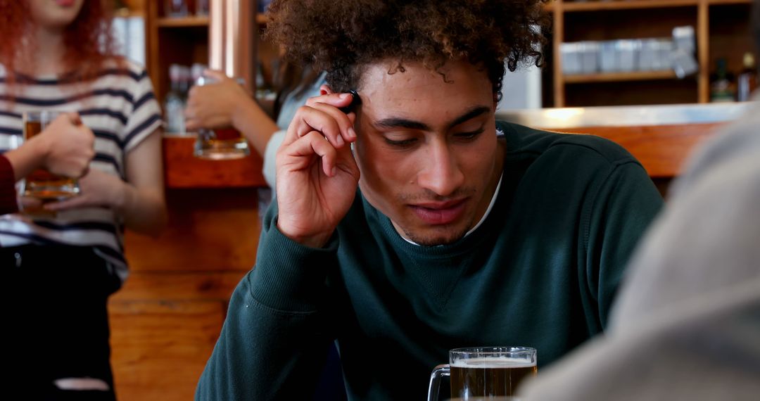 Young Man Enjoying Conversation in Bar with Friends
