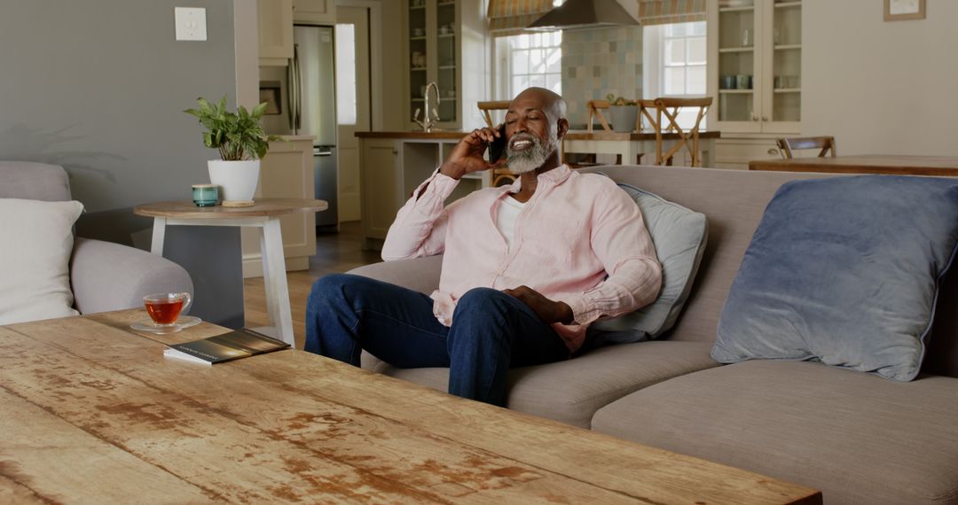 Senior Man Relaxed on Sofa Engaging in Phone Conversation