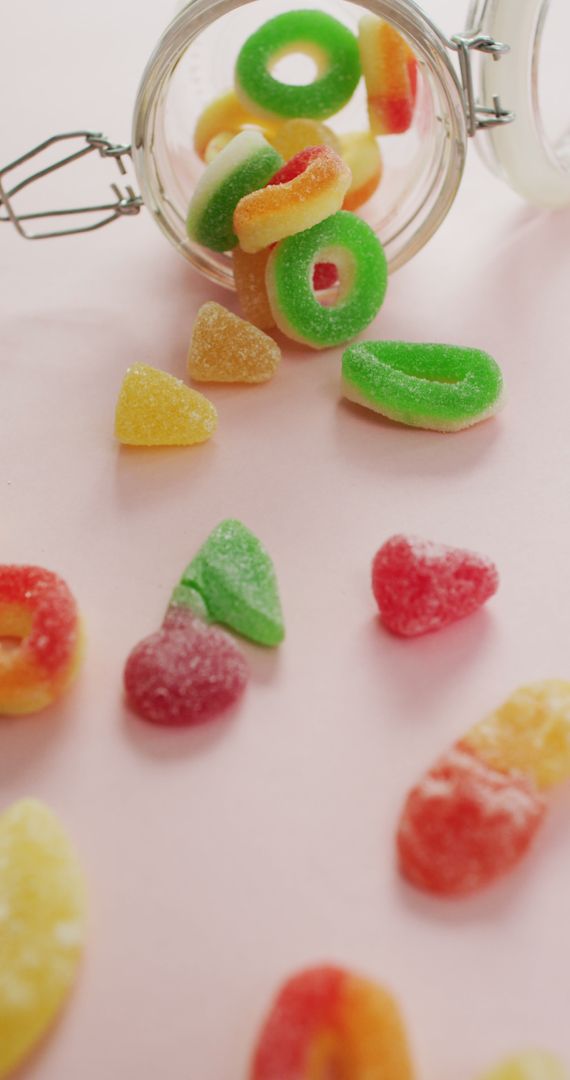 Colorful Jelly Candy Spilling from Glass Jar on Pink Background - Free Images, Stock Photos and Pictures on Pikwizard.com