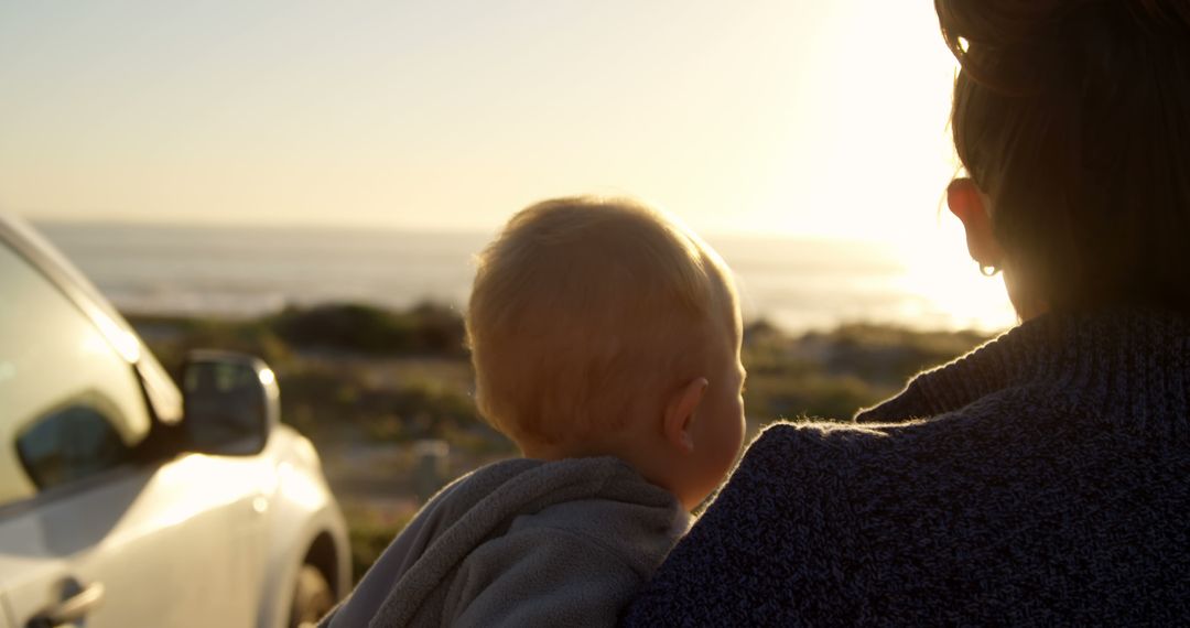 Mother Holding Baby Watching Sunset by the Ocean - Free Images, Stock Photos and Pictures on Pikwizard.com