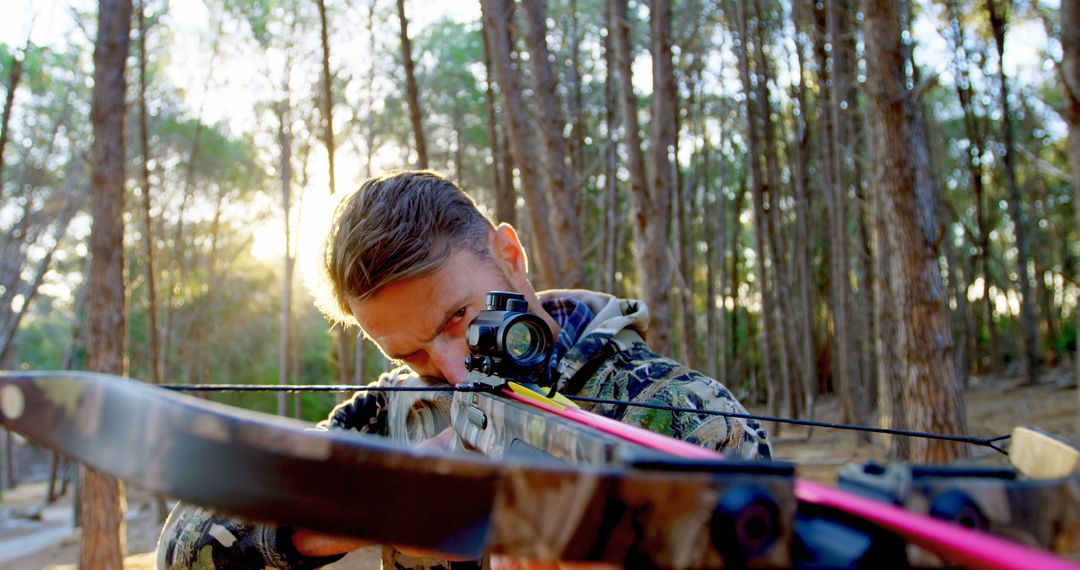 Young Male Archer Aiming Bow in Forest at Sunset - Free Images, Stock Photos and Pictures on Pikwizard.com