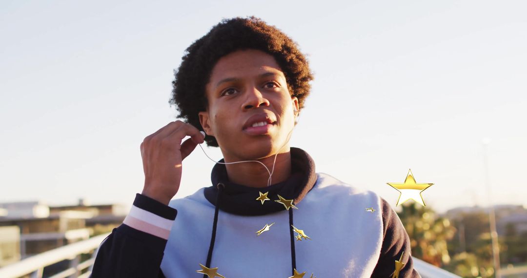 Young Man Adjusting Earbud on Bridge During Golden Hour