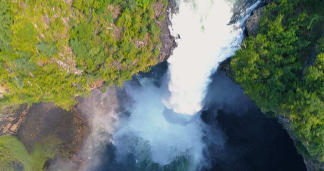 Aerial View of Powerful Waterfall Cascading into Misty Pool Surrounded by Lush Greenery - Free Images, Stock Photos and Pictures on Pikwizard.com