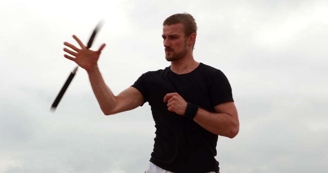 Man Practicing Martial Arts with Baton Outdoors - Free Images, Stock Photos and Pictures on Pikwizard.com