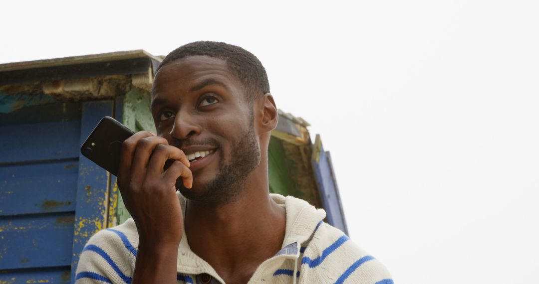 African American Man Smiling and Using Smartphone Outdoors - Free Images, Stock Photos and Pictures on Pikwizard.com