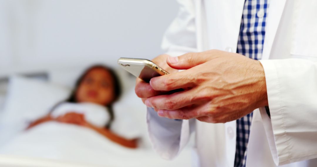 Doctor Checking Smartphone with Patient Resting in Background - Free Images, Stock Photos and Pictures on Pikwizard.com