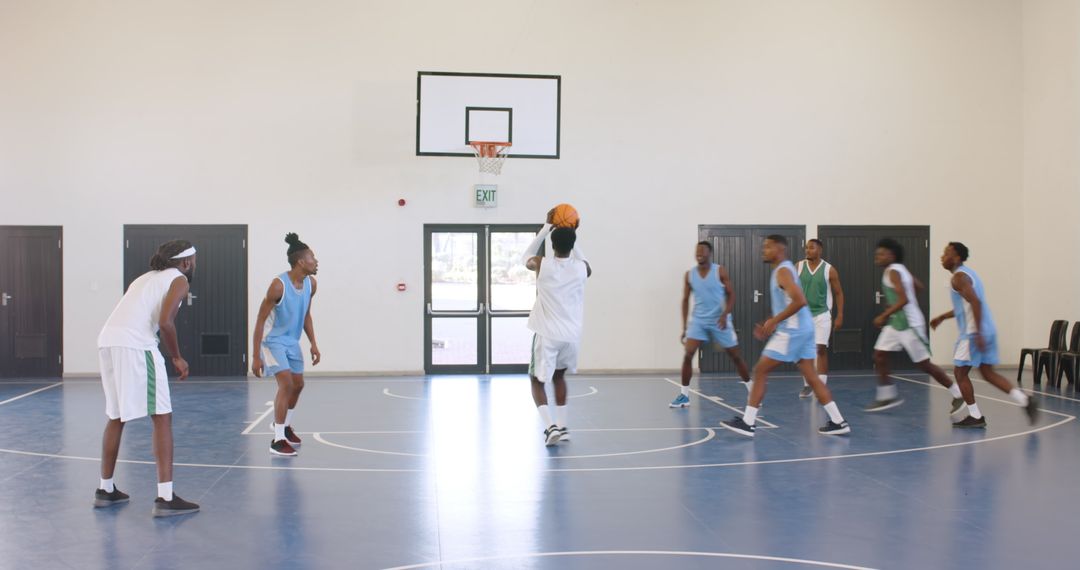 Energetic Basketball Game Indoors with Players on Blue Court