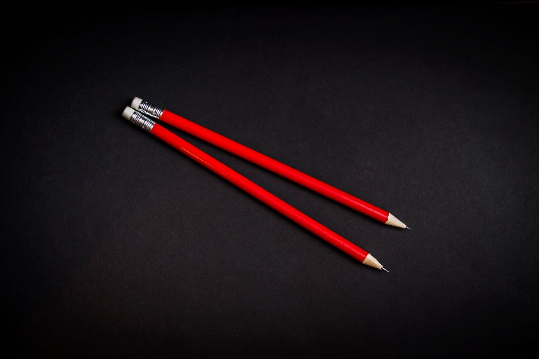 Two Red Pencils with Erasers on Black Background - Free Images, Stock Photos and Pictures on Pikwizard.com