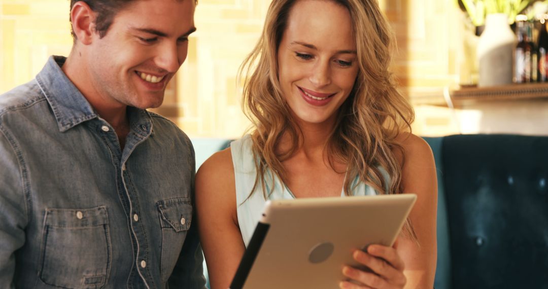 Couple Smiling and Using Digital Tablet Indoors - Free Images, Stock Photos and Pictures on Pikwizard.com