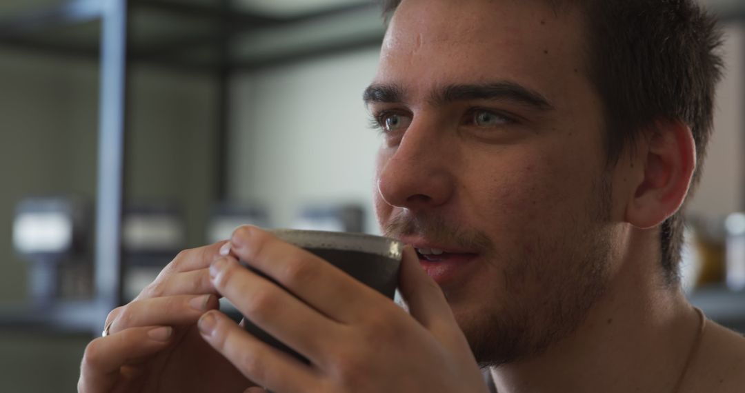 Young Man Enjoying a Hot Beverage in a Modern Cafe - Free Images, Stock Photos and Pictures on Pikwizard.com