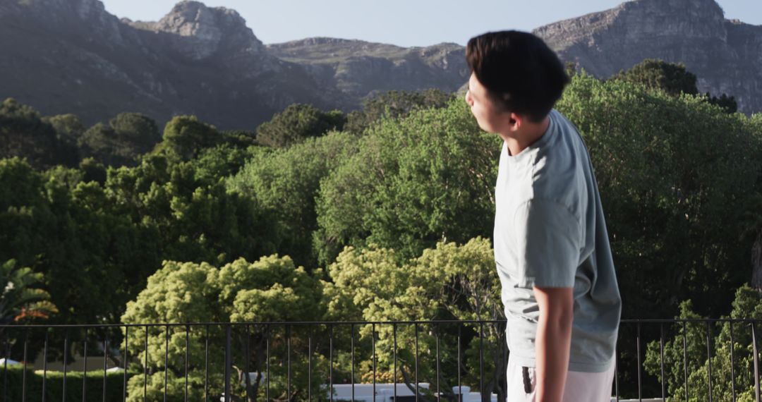 Man Enjoying Scenic Landscape from Balcony