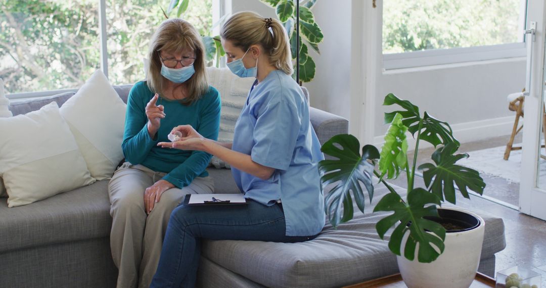 Senior Woman in Mask Consulting with Caring Nurse at Home - Free Images, Stock Photos and Pictures on Pikwizard.com