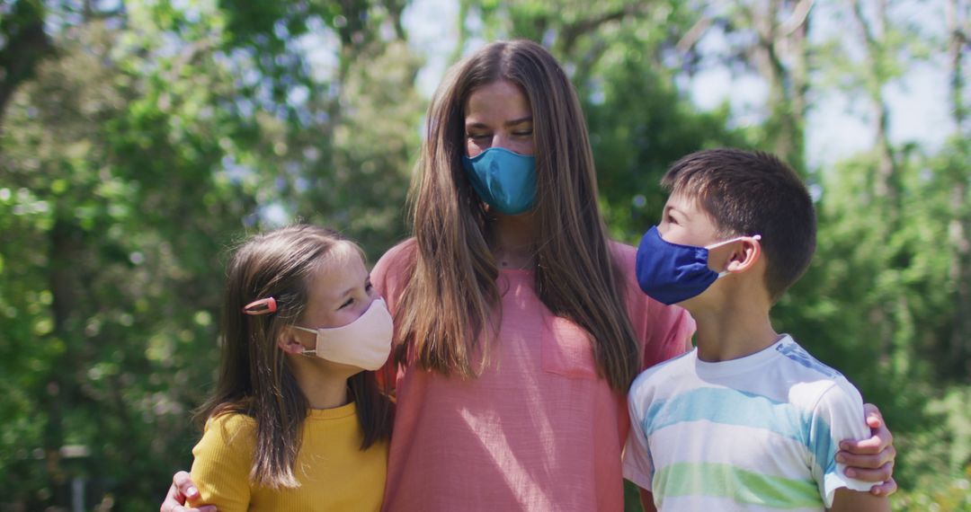 Family Embracing Outdoors Wearing Face Masks in Park - Free Images, Stock Photos and Pictures on Pikwizard.com