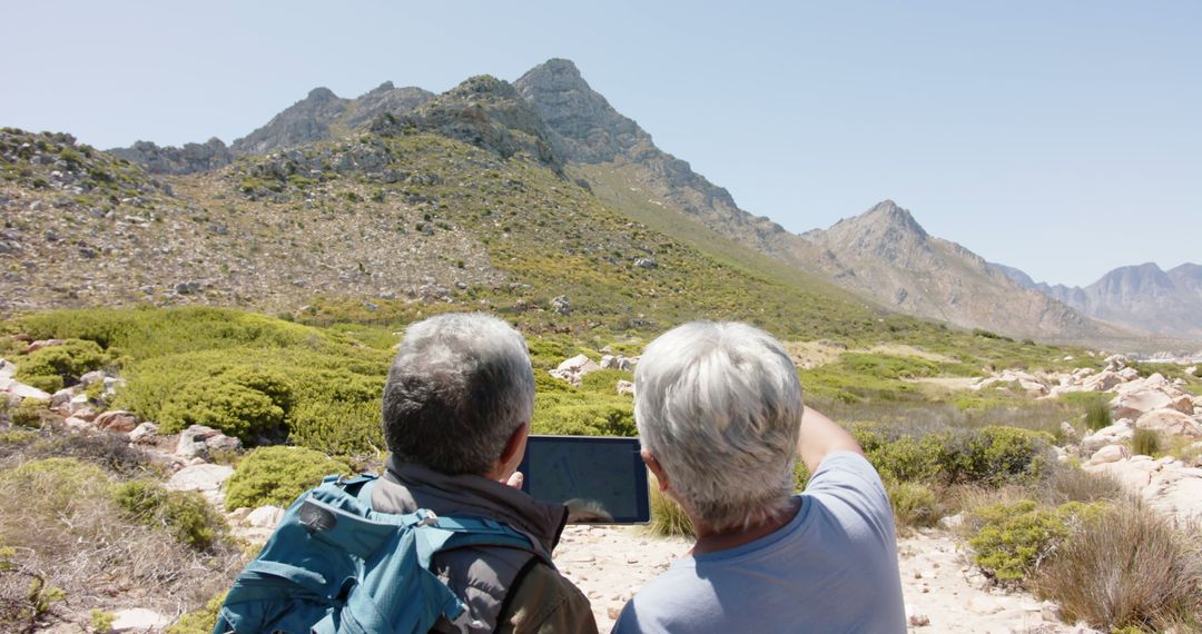 Senior Hikers Using Tablet to Navigate Mountainous Terrain - Free Images, Stock Photos and Pictures on Pikwizard.com