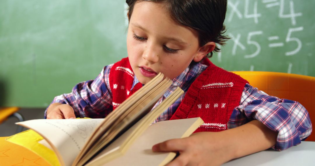 Young Boy Reading Book in Classroom - Free Images, Stock Photos and Pictures on Pikwizard.com