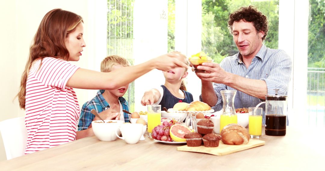 Happy Family Enjoying Breakfast Together at Table with Light Background - Free Images, Stock Photos and Pictures on Pikwizard.com