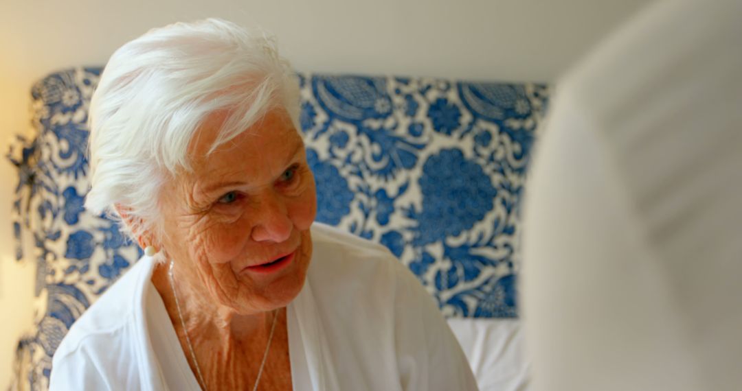 Elderly woman smiling and engaging in conversation - Free Images, Stock Photos and Pictures on Pikwizard.com