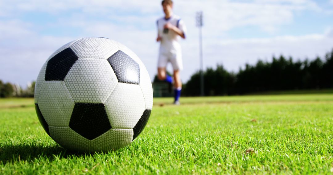 Soccer Ball on Grass with Player in Background - Free Images, Stock Photos and Pictures on Pikwizard.com