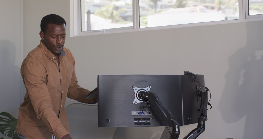 Professional Man Adjusting Monitor in Modern Office