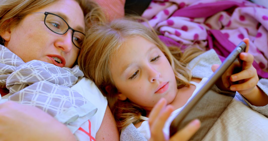 Mother and daughter lying on bed and using digital tablet - Free Images, Stock Photos and Pictures on Pikwizard.com