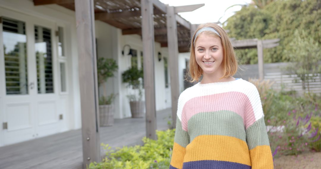 Young Woman Enjoying Tranquil Outdoor Setting in Cozy Multicolored Sweater