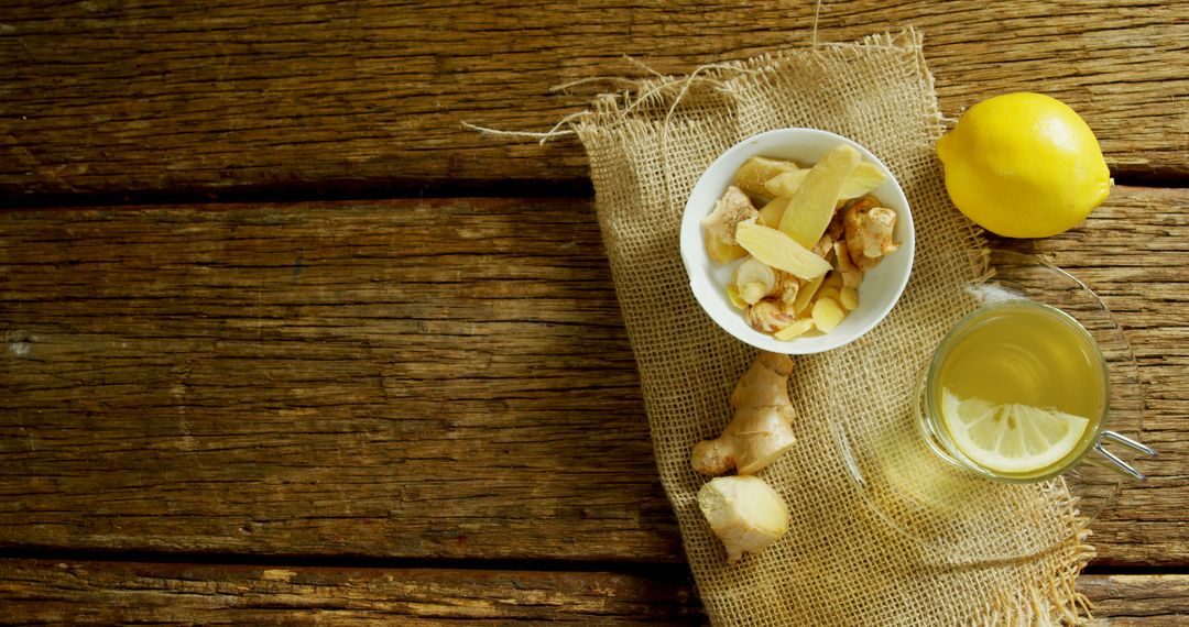 A bowl of ginger and a cup of ginger tea with lemon on a rustic wooden table, with copy space - Free Images, Stock Photos and Pictures on Pikwizard.com