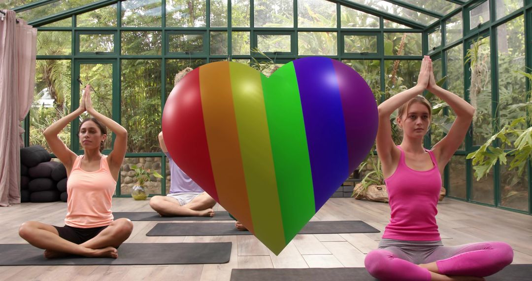 Practicing Yoga in Glasshouse with Rainbow Heart Symbolizing Pride and Mindful Wellness