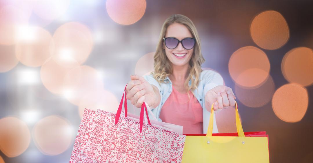 Happy Woman Holding Shopping Bags with Bokeh Background - Free Images, Stock Photos and Pictures on Pikwizard.com