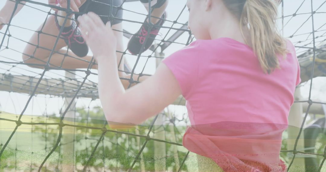 Woman Navigating Rope Net in Outdoor Obstacle Course