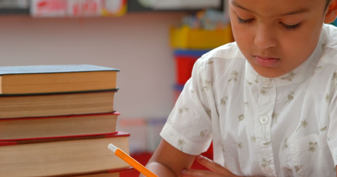 Focused Schoolboy Writing at Desk in Classroom