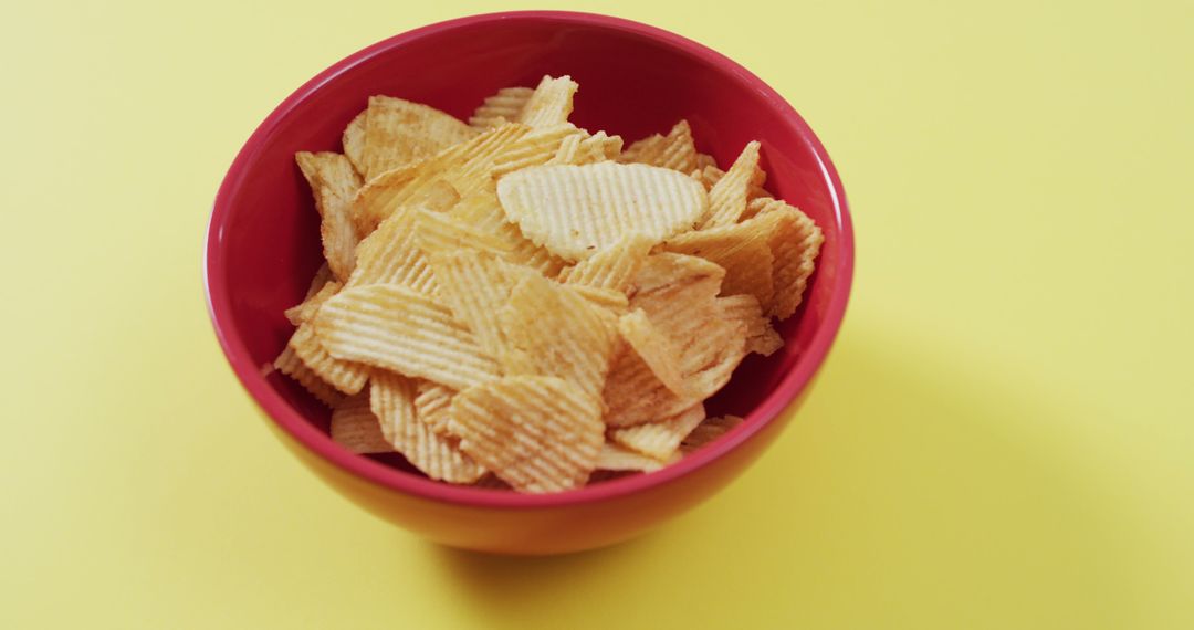 Close up of potato chips in a bowl with copy space on yellow surface - Free Images, Stock Photos and Pictures on Pikwizard.com