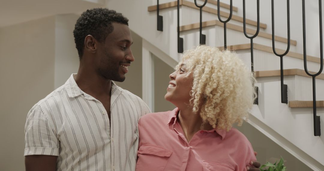 Smiling Friends Enjoying Conversation near Staircase at Home