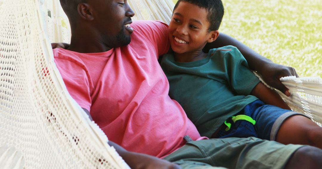 Father and Son Relaxing in Hammock Together Outdoors - Free Images, Stock Photos and Pictures on Pikwizard.com