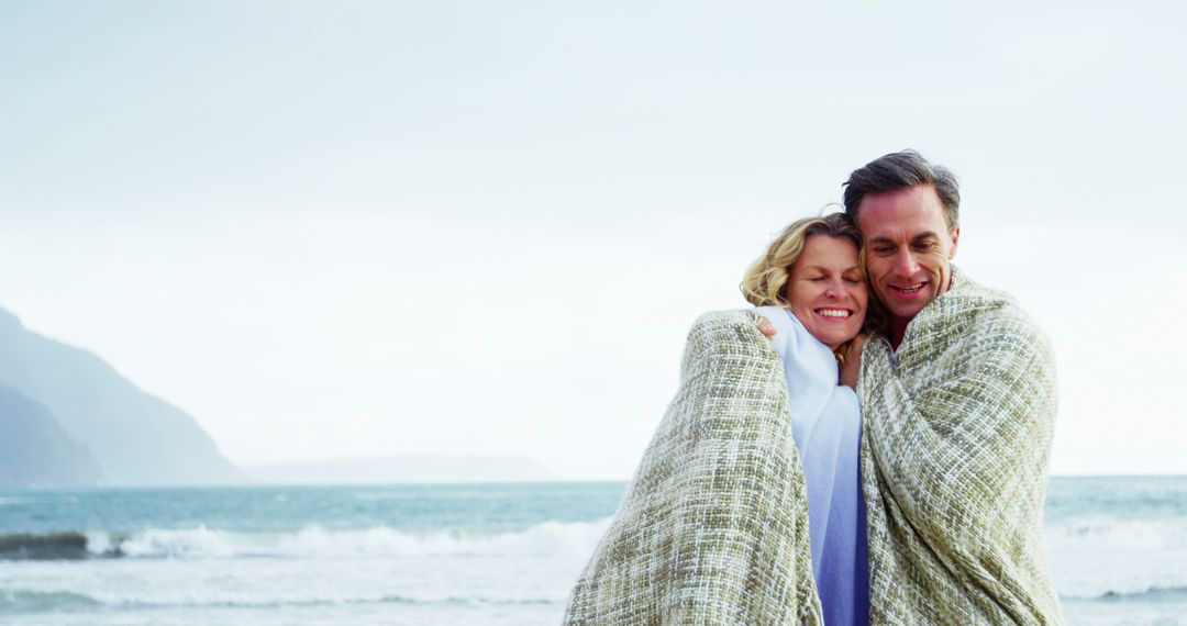 Senior Couple Embracing Under Blanket by Ocean Shore - Free Images, Stock Photos and Pictures on Pikwizard.com