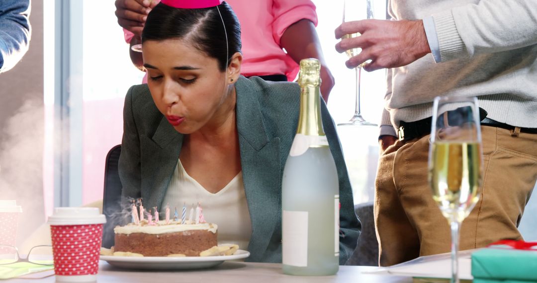 Businesswoman Blowing Out Birthday Candles During Office Celebration - Free Images, Stock Photos and Pictures on Pikwizard.com