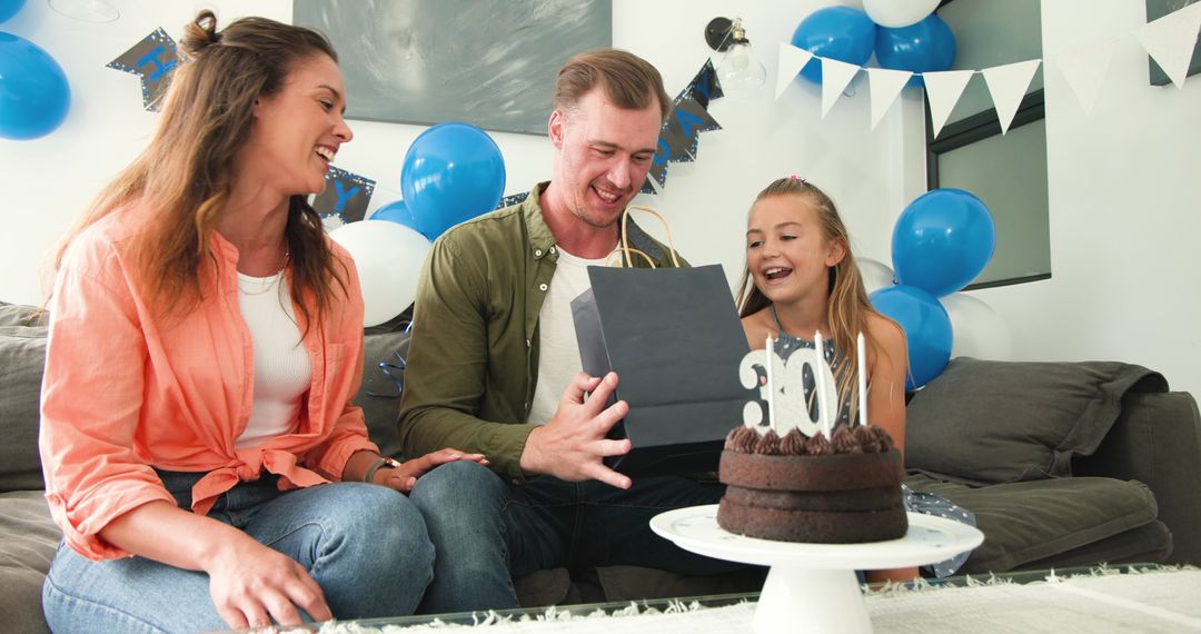 Celebrating family birthday with cake and gifts at home party