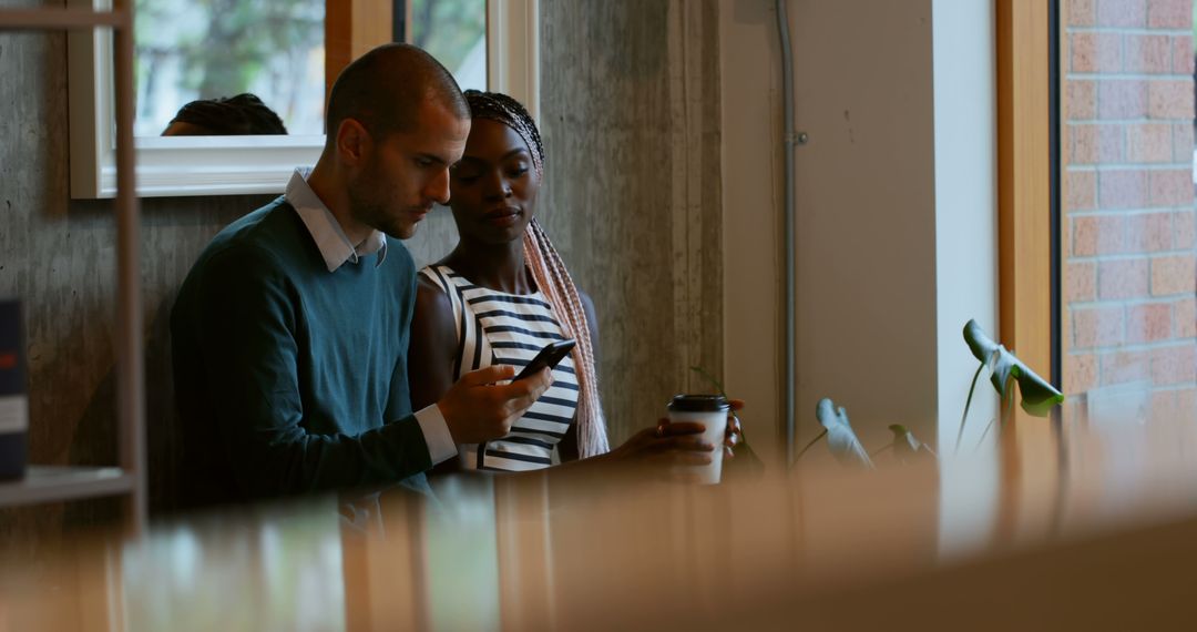 Colleagues Discussing Work and Exploring Ideas on Smartphone