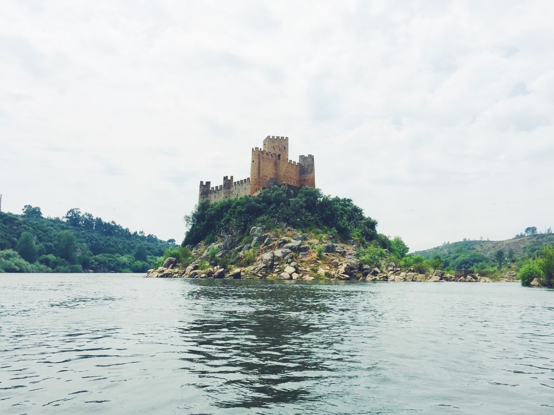 Scenic Medieval Castle on Hilltop Surrounded by River - Free Images, Stock Photos and Pictures on Pikwizard.com