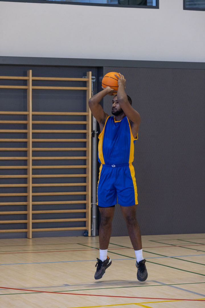 Basketball Player Executing Jump Shot in Indoor Gymnasium